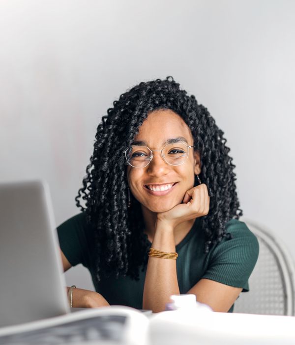 Professora de inglês sorrindo diante do computador